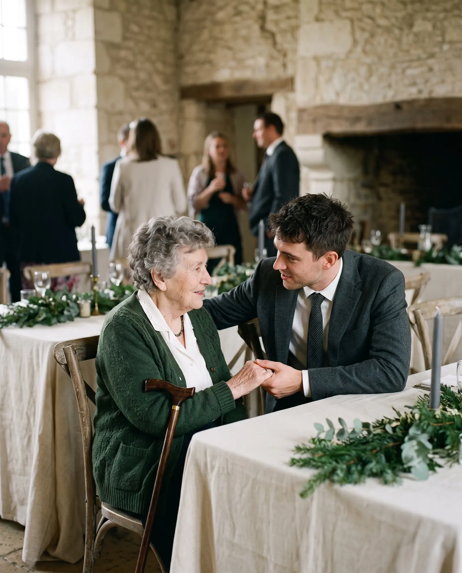 A grandmother with a walking stick holds hands with her grandson at a reception table